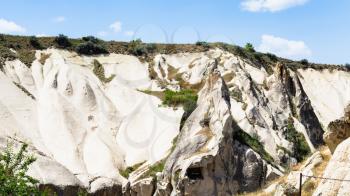 Travel to Turkey - slope of valley with rock-cut ancient monastic settlement near Goreme town in Cappadocia in spring
