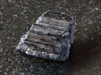macro shooting of natural rock specimen - crystal of black Tourmaline (Schorl) gemstone on dark granite background