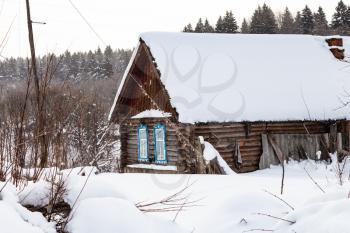 old typical russian rural house in overcast winter day in little village in Smolensk region of Russia