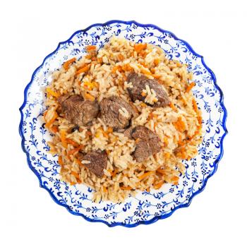 top view of cooked pilaf (central asian dish from rice with meat and vegetable) on local ceramic plate isolated on white background