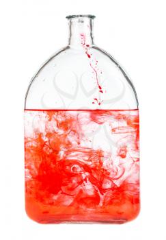 red dye dissolves in water in glass flask isolated on white background