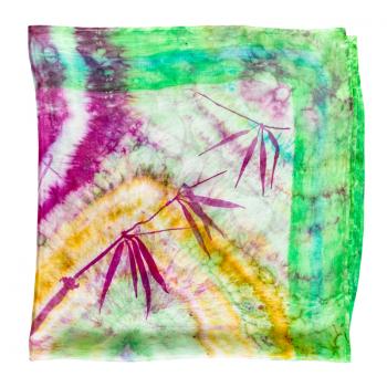 folded colorful colored batik silk scarf with hand-drawn bamboo twig isolated on white background