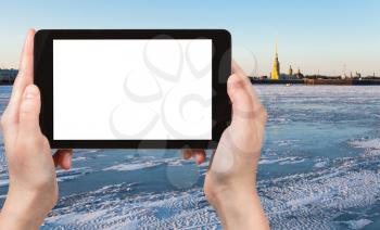 travel concept - tourist photographs of ice covered Neva river and Peter and Paul Fortress in Saint Petersburg city in March on smartphone with empty cutout screen with blank place for advertising