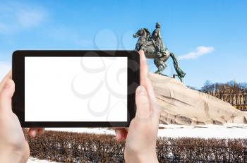 travel concept - tourist photographs of Bronze Horseman sculpture of Peter the Great in the Senate Square in Saint Petersburg city on smartphone with cutout screen with blank place for advertising