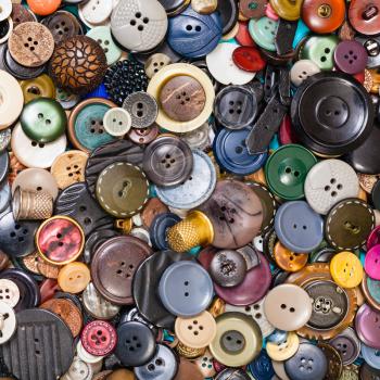 top view of heap of many various buttons close up on blue