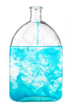 blue watercolour dissolves in water in bottle isolated on white background