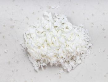 top view of pile of coconut flakes close up on gray ceramic plate