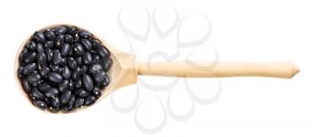top view of wood spoon with uncooked black mexico beans isolated on white background