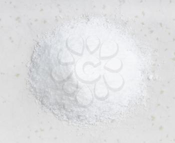top view of pile of crystalline monosodium glutamate flavoring close up on gray ceramic plate