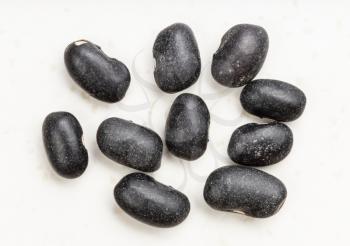 several raw black turtle beans close up on gray ceramic plate