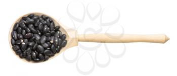 top view of wood spoon with raw black turtle beans isolated on white background