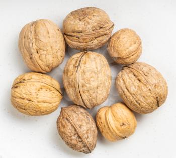 several whole walnuts close up on gray ceramic plate