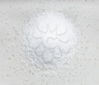 top view of pile of sugar substitute - crystalline extract of stevia plant close up on gray ceramic plate