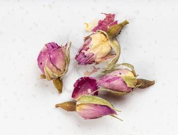 several old dried rosebuds close up on gray ceramic plate