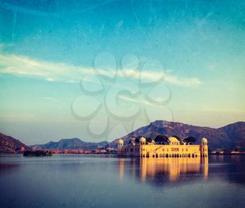 Vintage retro hipster style travel image of Rajasthan landmark - Jal Mahal (Water Palace) on Man Sagar Lake on sunset with grunge texture overlaid.  Jaipur, Rajasthan, India