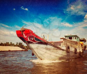 Vintage retro hipster style travel image of boat on Mekong river delta, Vietnam with grunge texture overlaid
