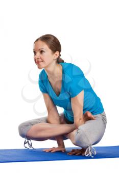 Yoga - young beautiful woman yoga instructor doing Cock Pose (Rooster Posture) (Kukkutasana) asana exercise isolated on white background