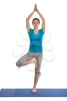 Yoga - young beautiful woman yoga instructor doing Tree pose asana (Vrikshasana) exercise isolated on white background