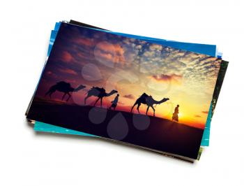 Holidays travel concept creative background - stack of vacation photos with camel caravan sunset image on top isolated on white background