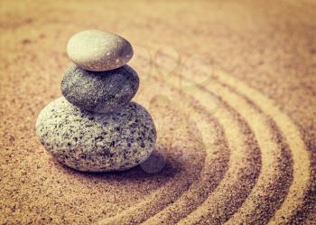 Vintage retro effect filtered hipster style image of Japanese Zen stone garden - relaxation, meditation, simplicity and balance concept  - pebbles and raked sand tranquil calm scene