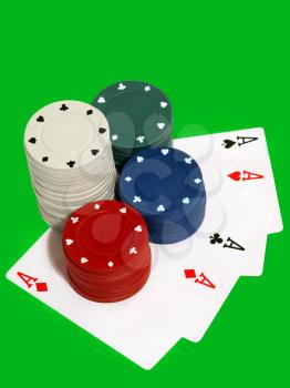Casino chips and play cards isolated on green background.