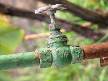 Old metal faucet and rusty pipeline taken closeup.