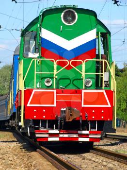 Multicolored locomotive on the rails closeup.