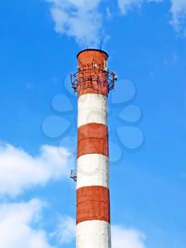 High smoking chimney against of blue sky.
