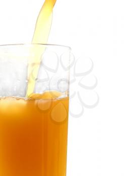 Orange juice pouring in glass on white background taken closeup.