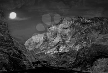 Night mountains landscape with fool moon.Monochrome toned image.