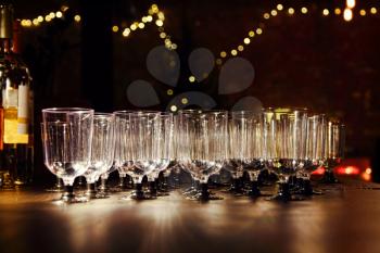 Empty wineglasses on holiday reception table in night-time lighting.