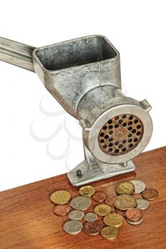 Meat grinder and coins on wooden table and white background.Financial concept.