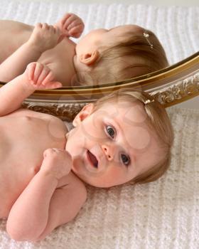 Naked baby posing by mirror