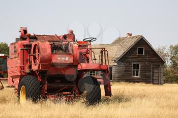 Abandoned combine and farm house in scenic Saskatchewan