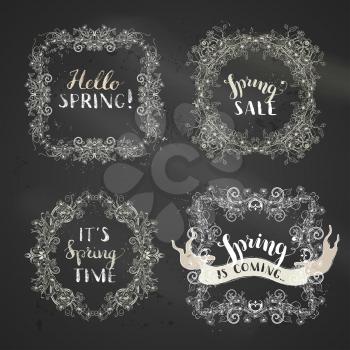 Outlined spring flowers and leaves on tree branches, birds and flourishes. Hand-written lettering. Page decorations on blackboard background.