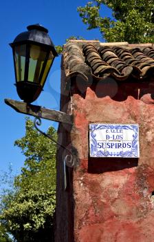 a street lamp plate plant and a wall in calle de los suspiros of house in colonia del sacramento  uruguay