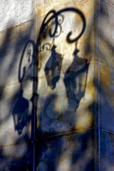 shadow of a street lamp  and a yellow orange marble  wall  in la boca buenos aires argentina