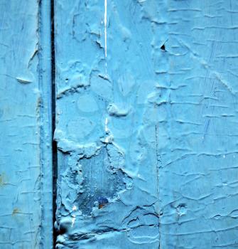 stripped paint in the blue wood door and rusty  nail