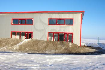 Frozen construction. Unfinished building among the snow-covered field in winter