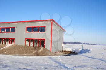 Frozen construction. Unfinished building among the snow-covered field