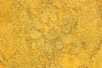 Multilayer painted shelled and cracked yellow surface outdoors as the texture