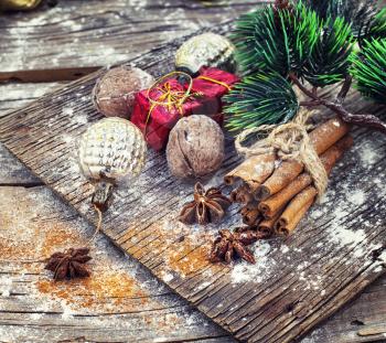 Old-fashioned Christmas decorations,cinnamon sticks,star anise and nuts on wooden retro background