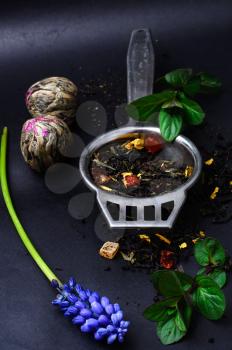 Varieties tea infuser spoon with custard on  dark background