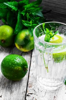 refreshing summer drink cocktail with lime and mint on a light background