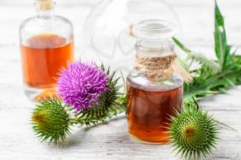 Flowering buds plant Thistle, and a small bottle of medicinal tincture