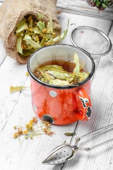Iron mug of tea brewed with dried medicinal inflorescence of Linden