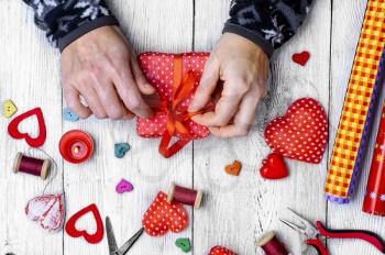 Packing holiday gifts for Valentine's day.Thread,button and symbolic heart.