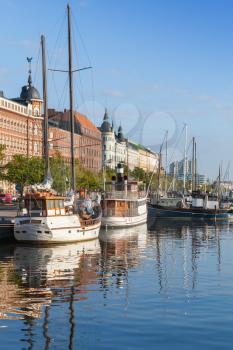 Old quay of Helsinki city with moored sailing ships and classical building facades in the morning light