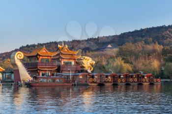 Hangzhou, China - December 5, 2014: Traditional Chinese wooden pleasure boats and Dragon ship stand on the West Lake. Famous park in Hangzhou city center, China