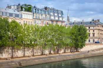 Seine river embankment with trees and old houses facades